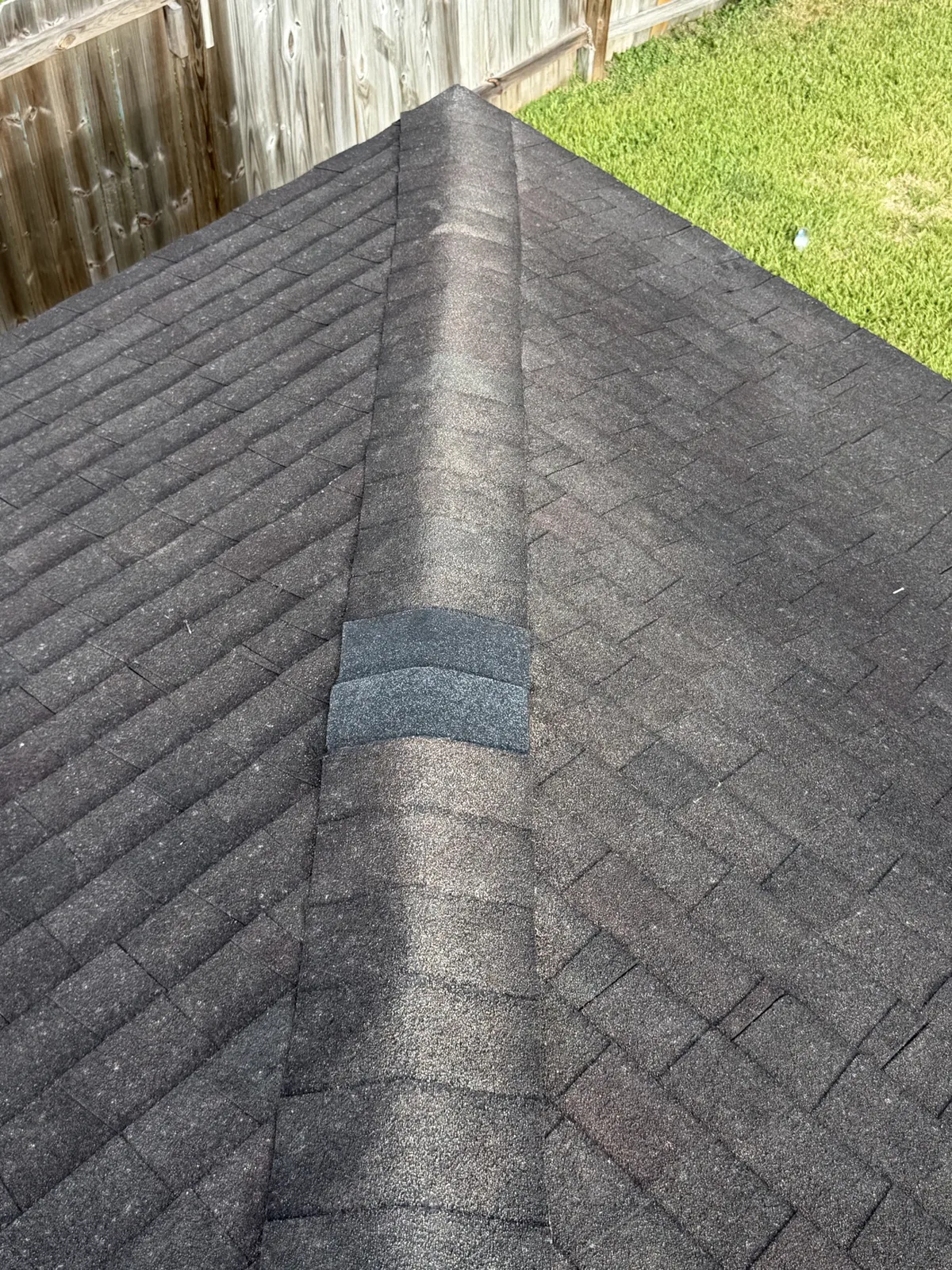 Repaired ridge caps on an asphalt shingle roof