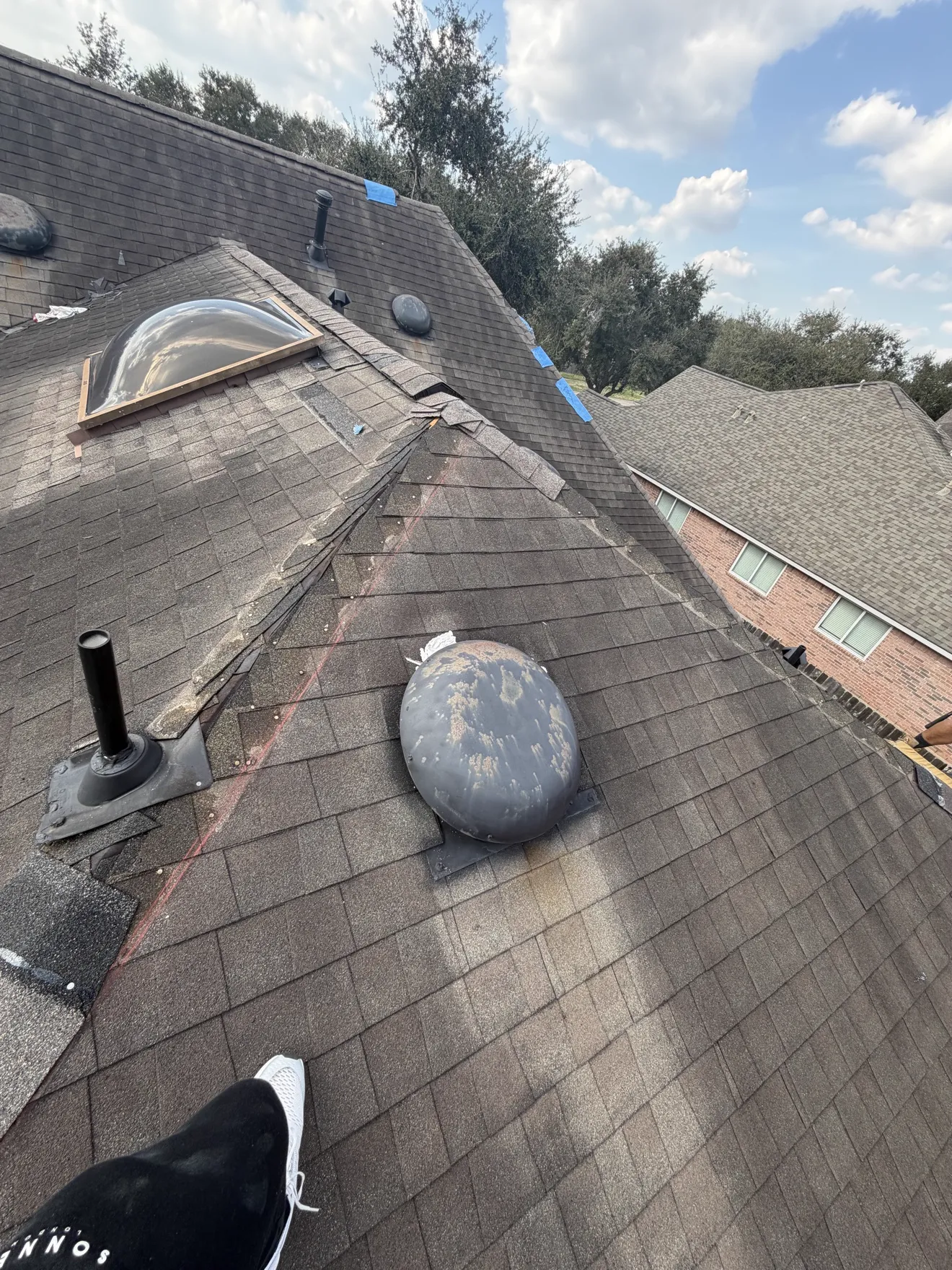 Roof ridge damage marked with blue tape during an emergency inspection