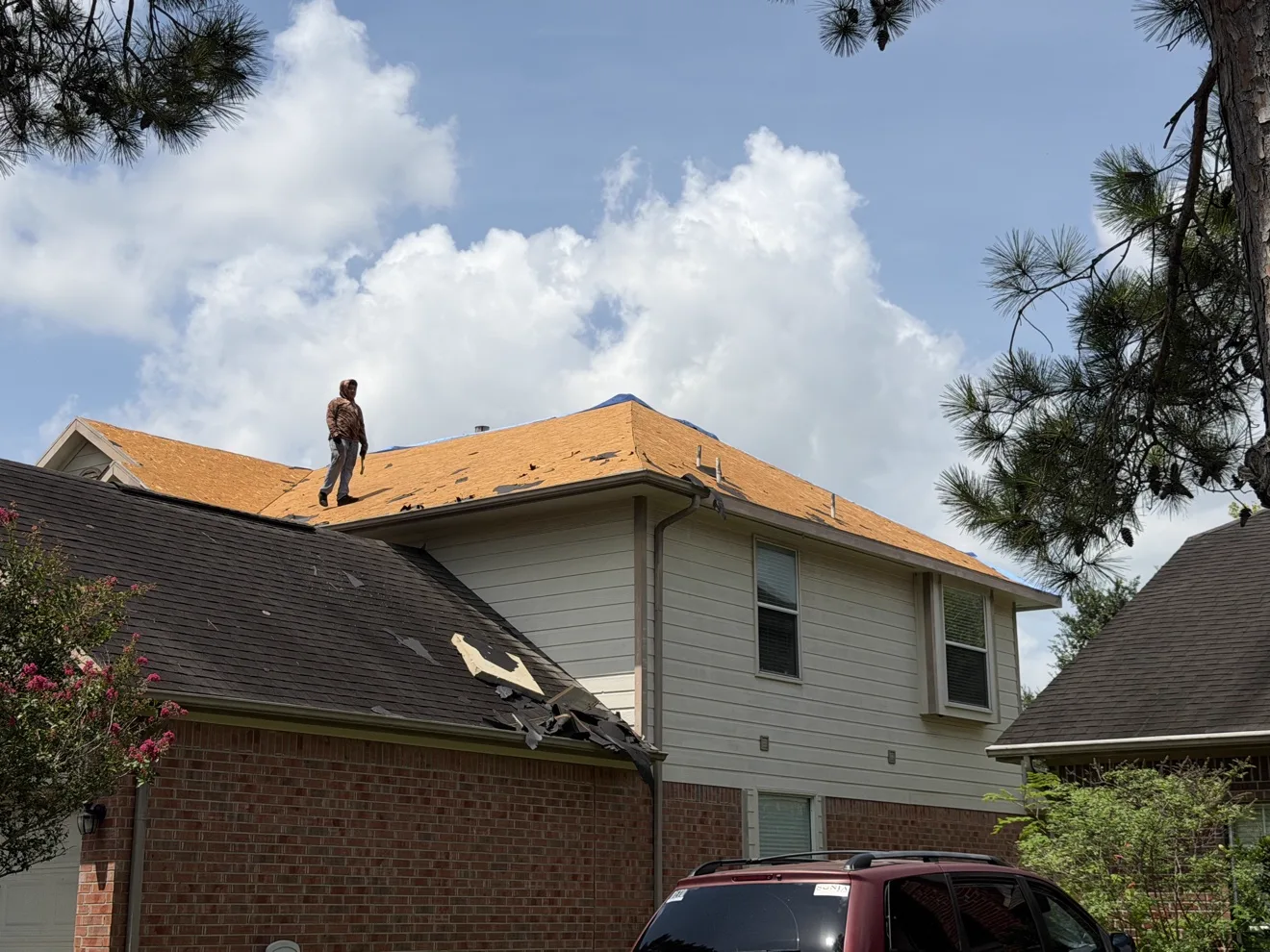 Madison Roofing crew member on a residential roof during a tear-off